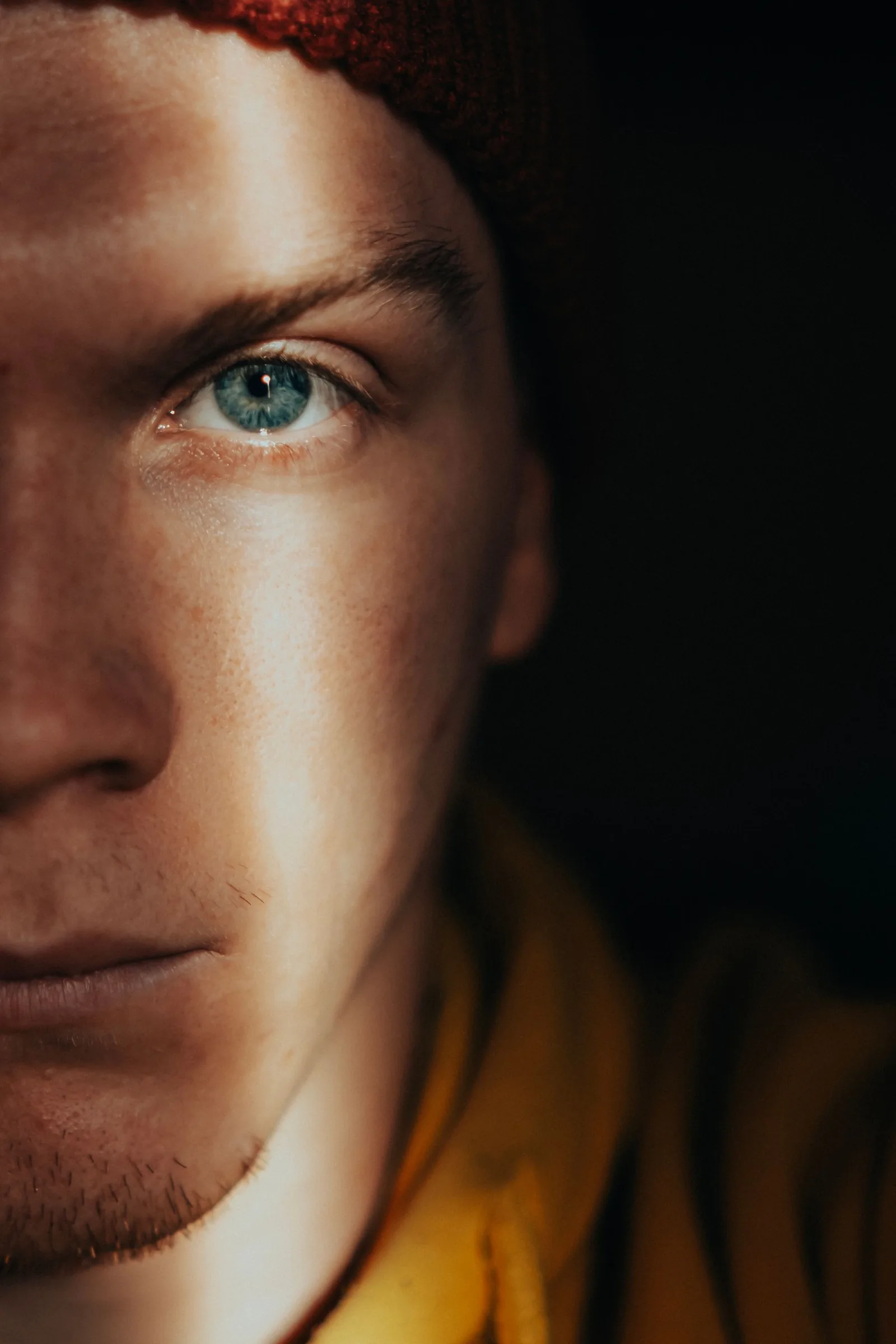 A man's face half in warm side light