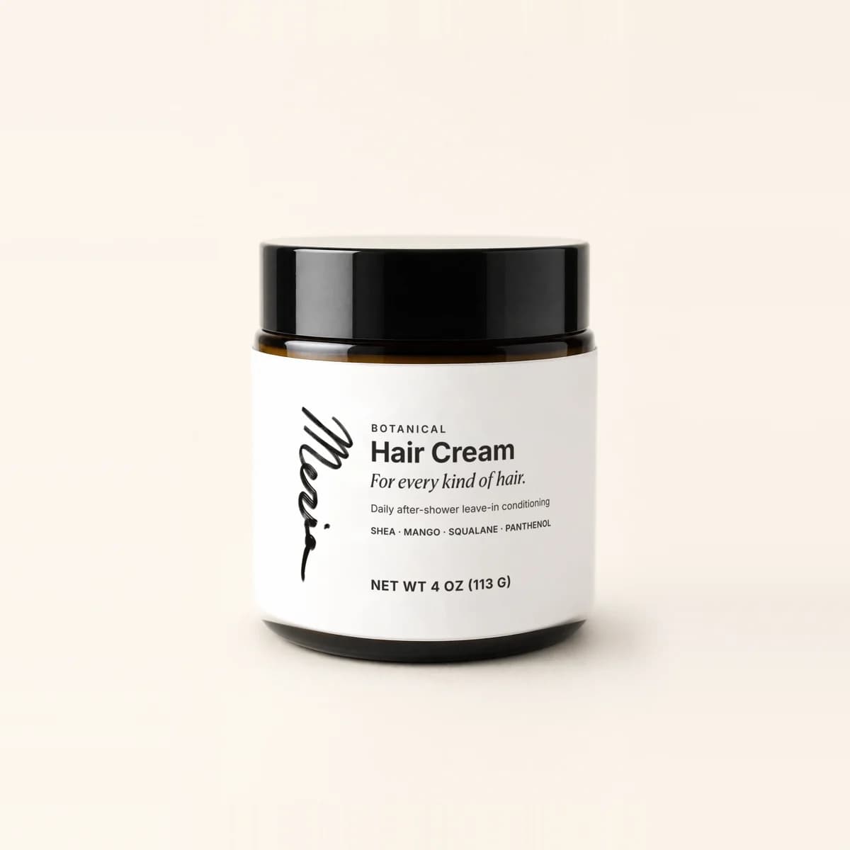 A closed jar of Meria Botanical Hair Cream with its black lid, at eye level on a plain studio backdrop